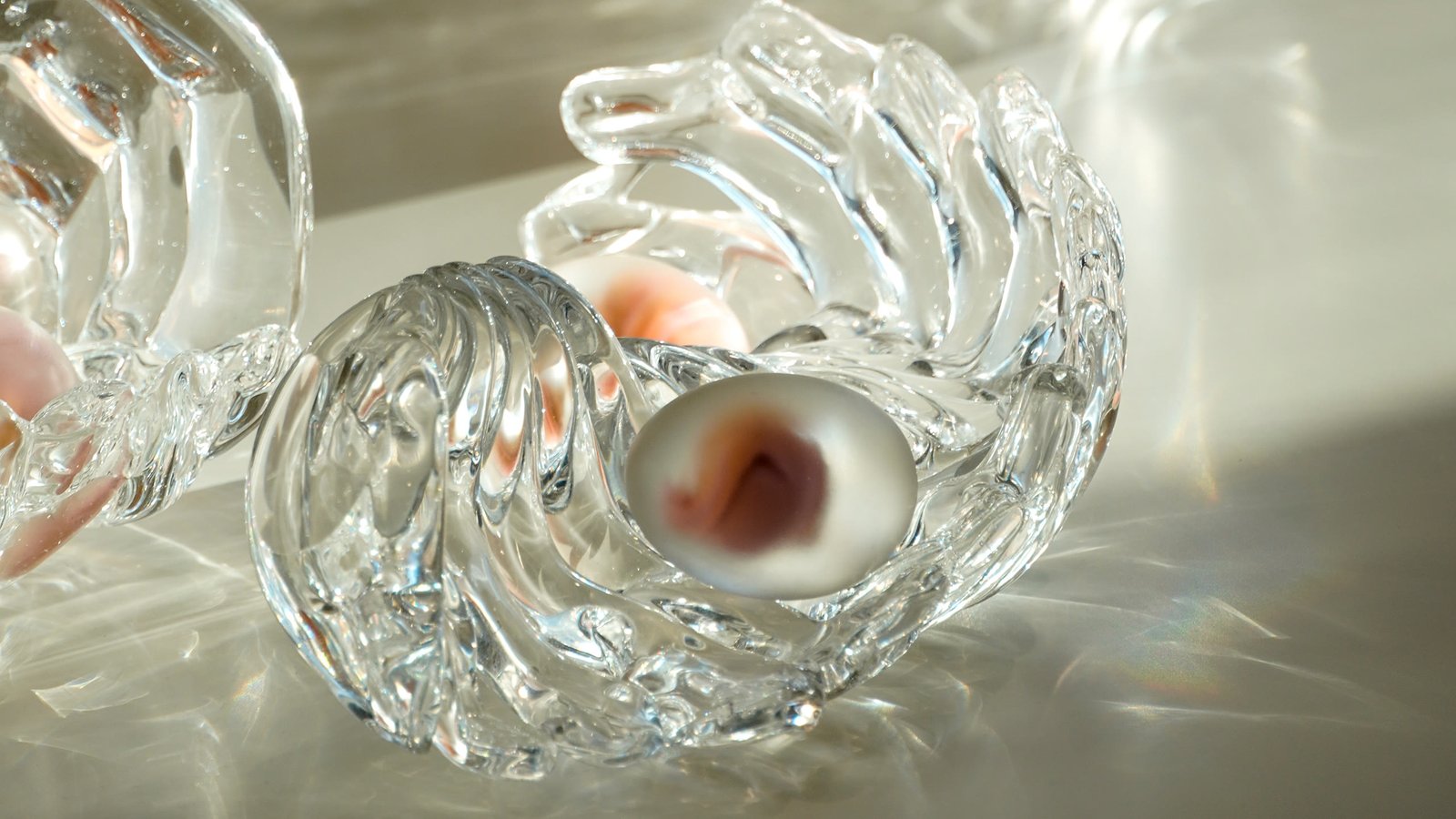 A clear ribbed form holding a pink nodule in bright light