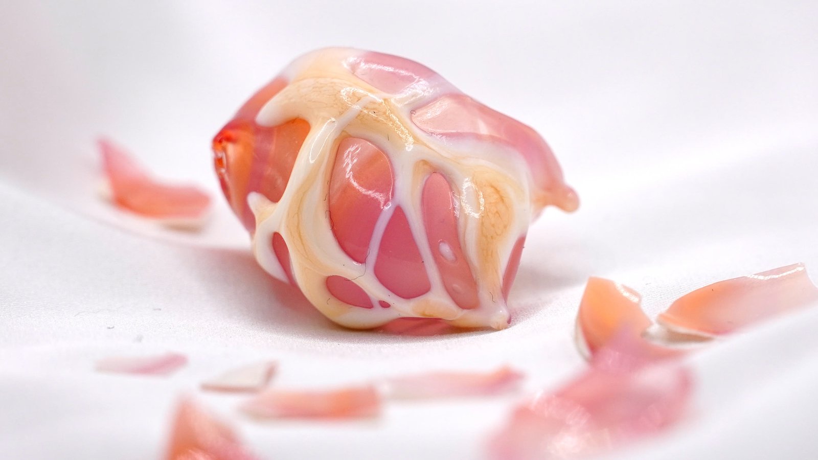 A webbed pink and cream flamework piece among scattered shards