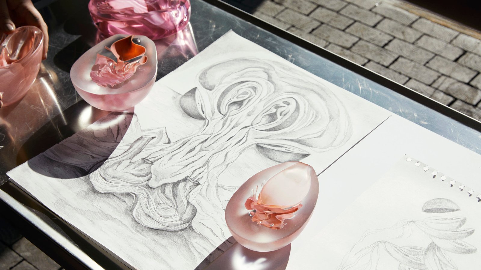 A glass piece resting on an anatomical pencil drawing outdoors