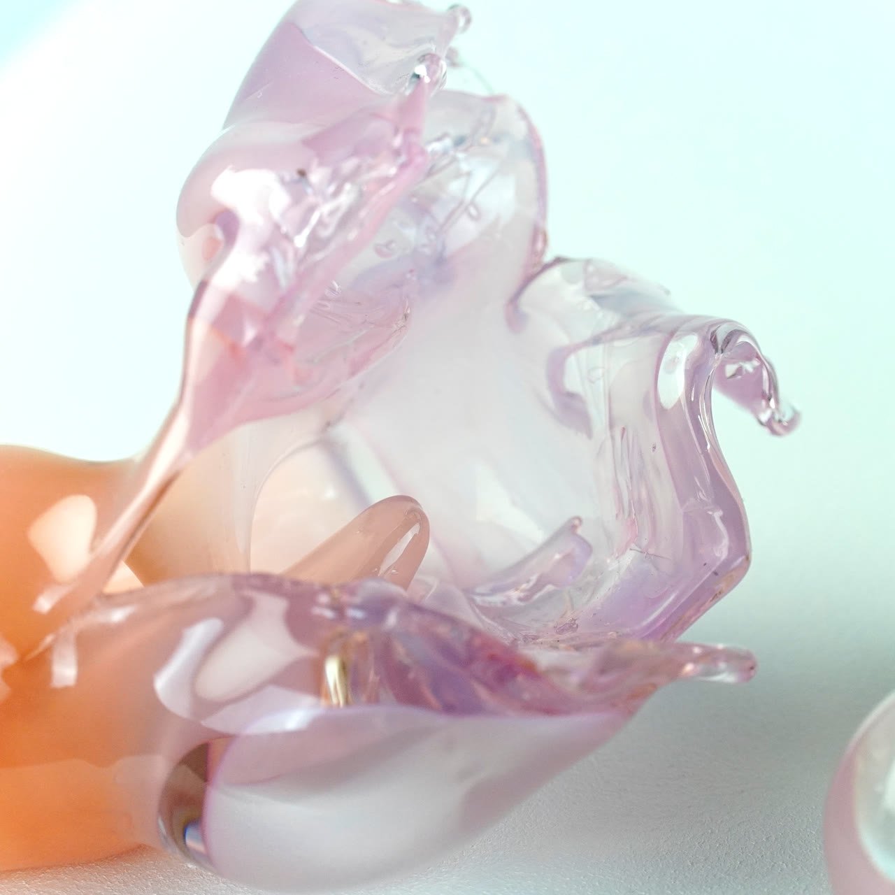 Close detail of pink and clear glass folds catching the light