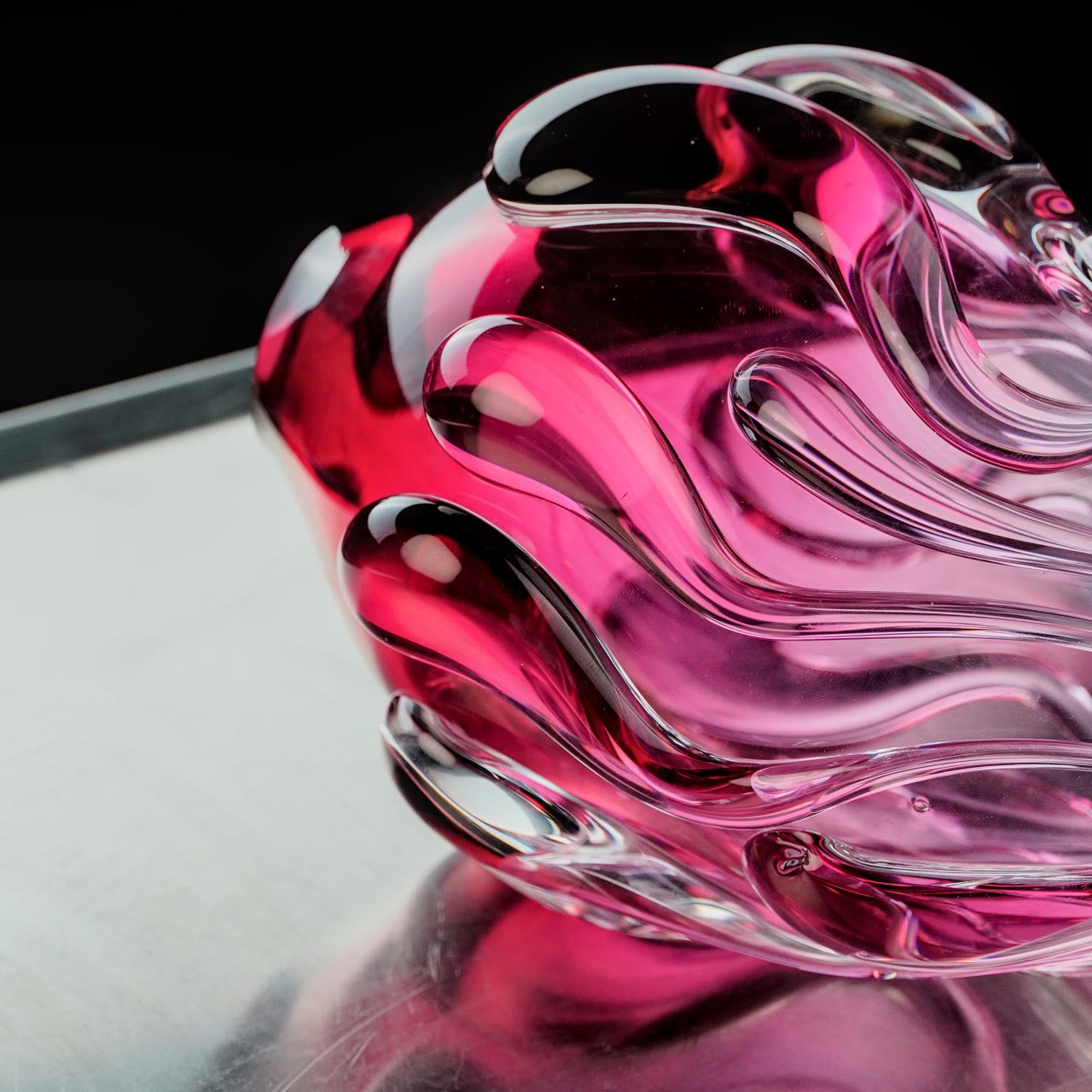 Close detail of the deep magenta core inside flowing pink glass