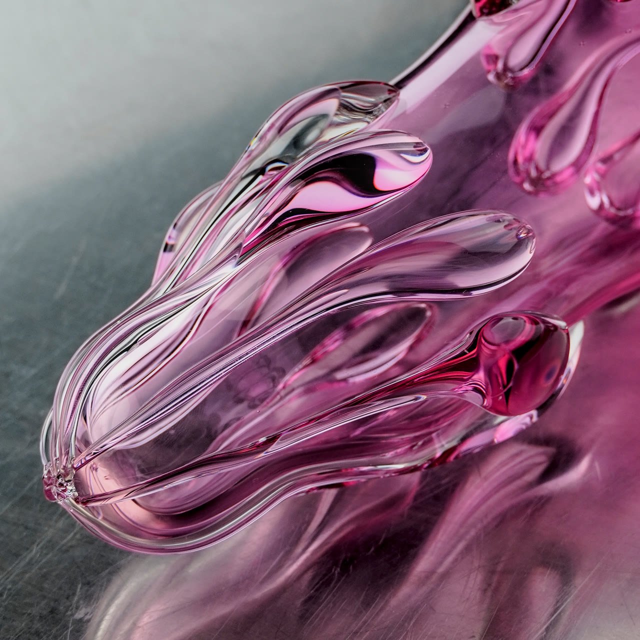 Close detail of pale pink teardrop forms against steel