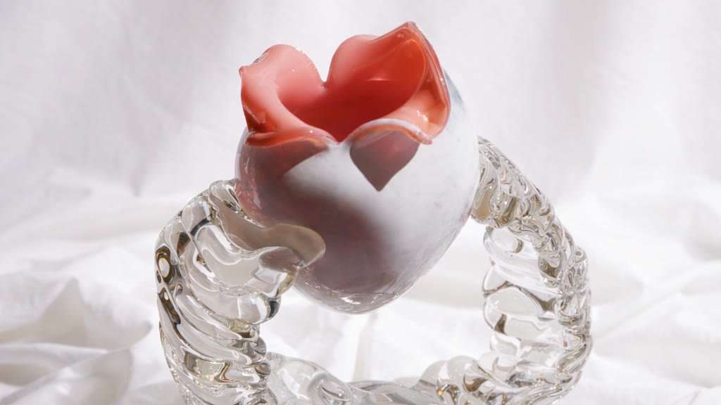 A vase with a coral mouth resting on white cloth